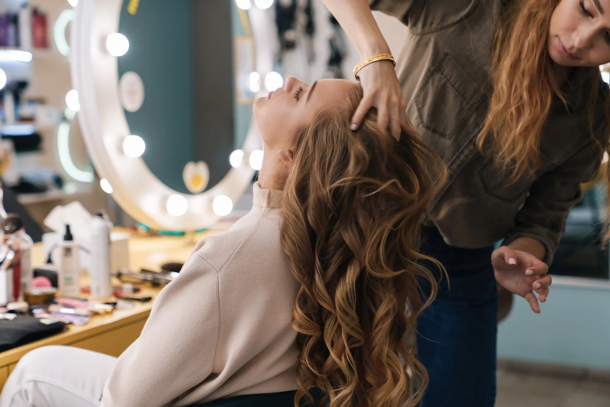 cabello de mujer color castaño ondulado y mujer peinando