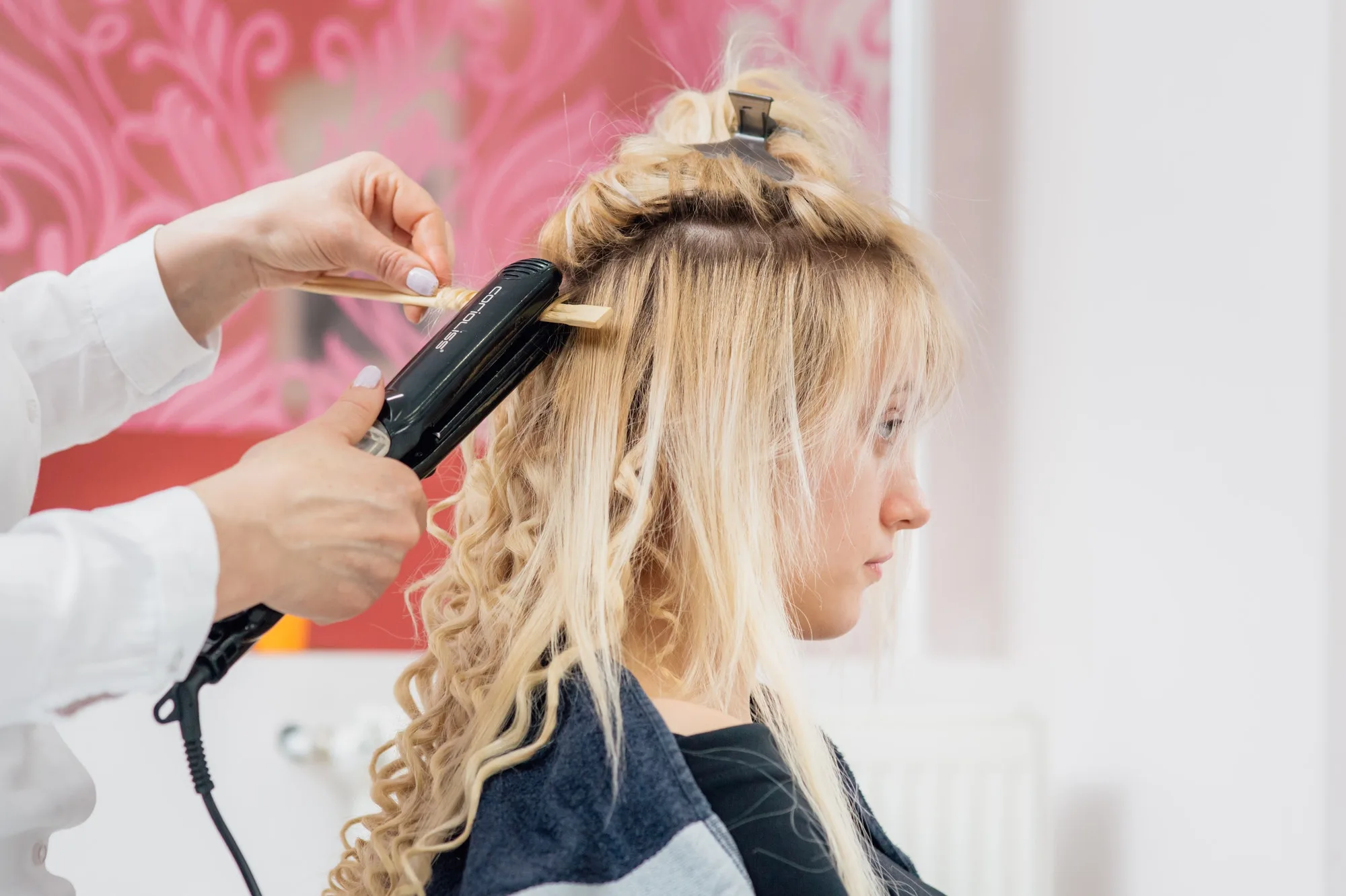 peluquera rizando el pelo a una clienta